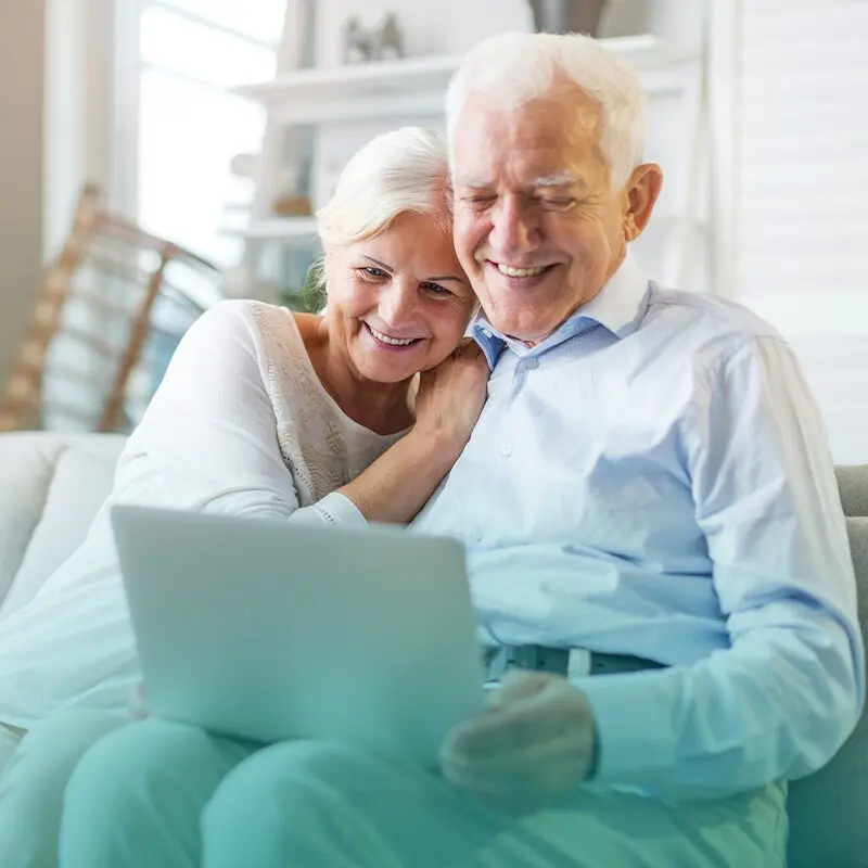 Adultos mayores realizan una videollamada con sus seres queridos.