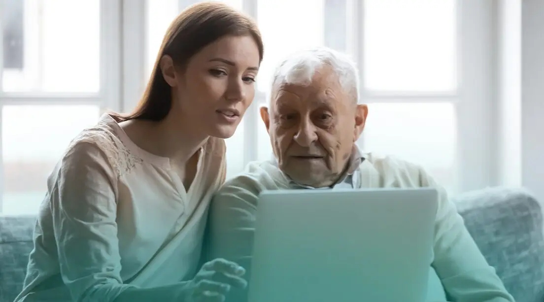 Persona mayor recibe consejos de su nieta sobre tecnología.