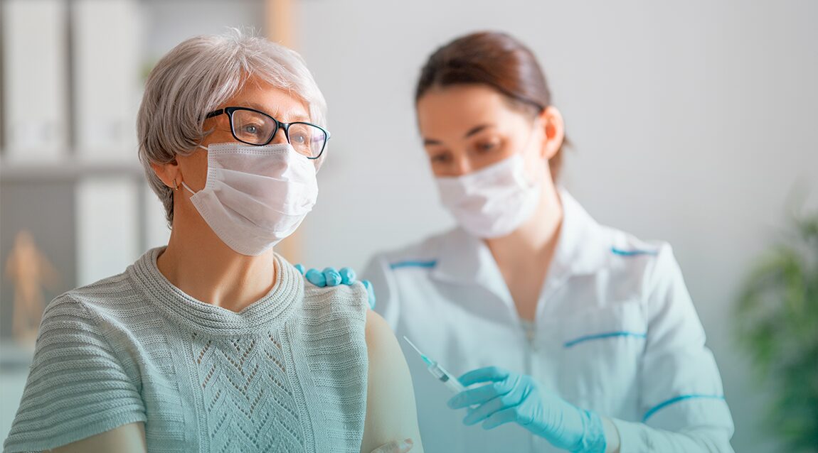 Adulto es atendido por una enfermera al aplicarse sus vacunas