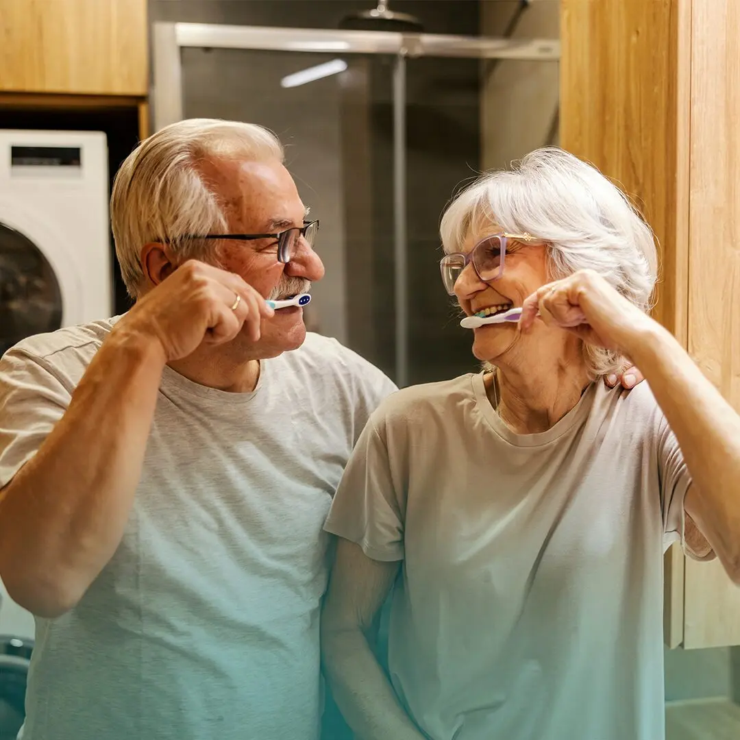 Adultos de mediana edad cepillándose los dientes.