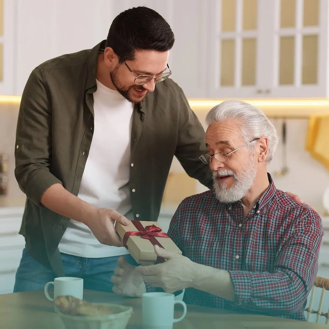 Adulto mayor recibe un regalo en temporada de fiestas.