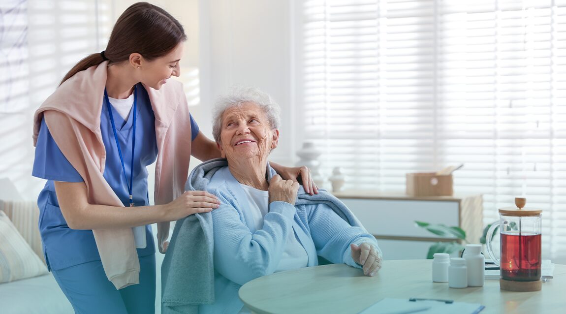 Cuidadora se encarga de un adulto mayor en temporada de invierno.