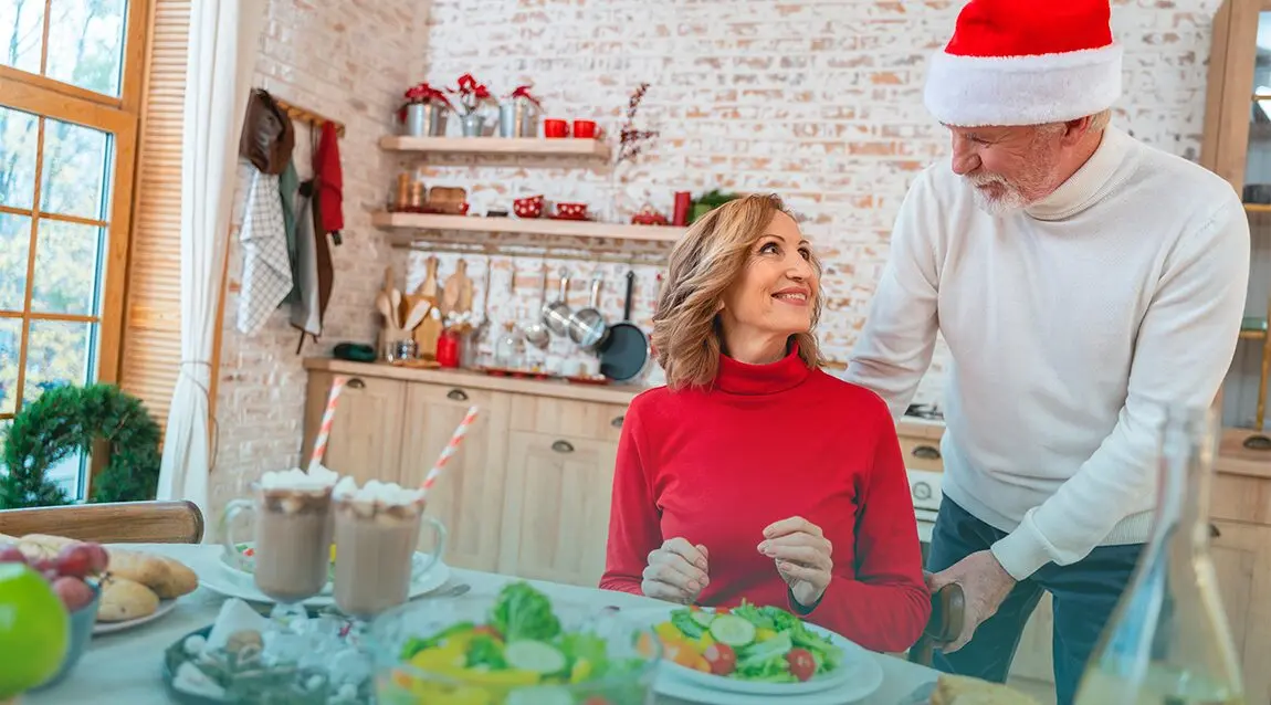 Pareja de adultos se prepara para comer durante las fiestas navideñas.