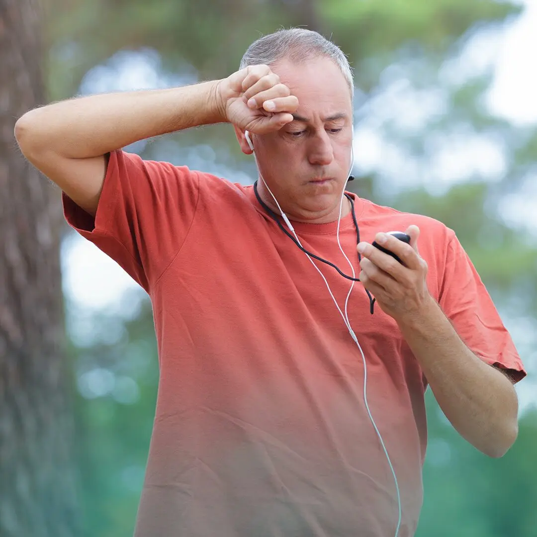 Adulto en la mediana edad, padeciendo el calor tras hacer ejercicio.