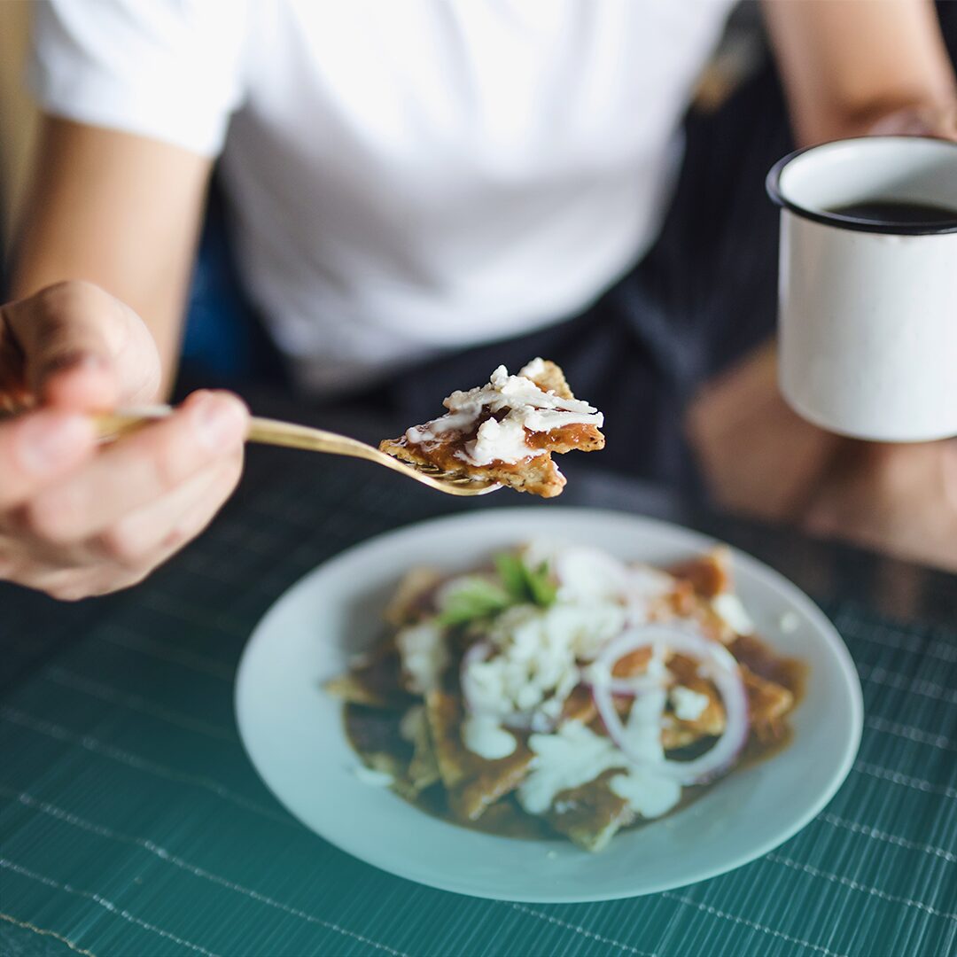 Adulto disfrutando un café y comida mexicana durante el mes patrio.